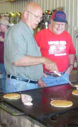 Photo of Community Club members making pancakes.